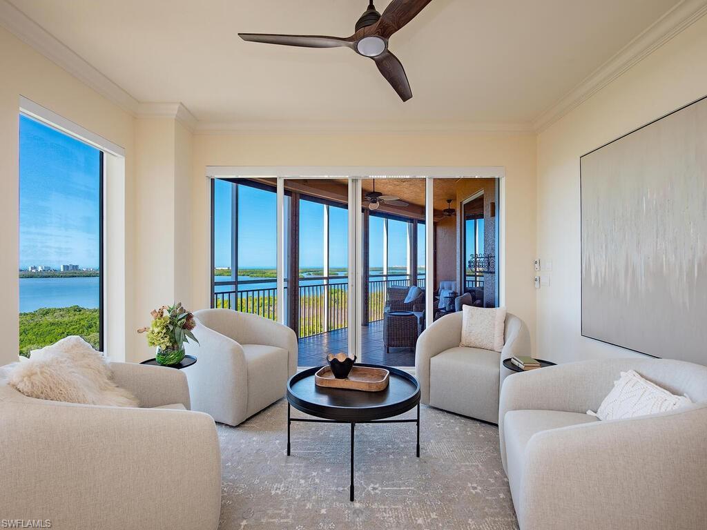 Image 4: Living area featuring a water view, ornamental molding, a sunroom, and ceiling fan