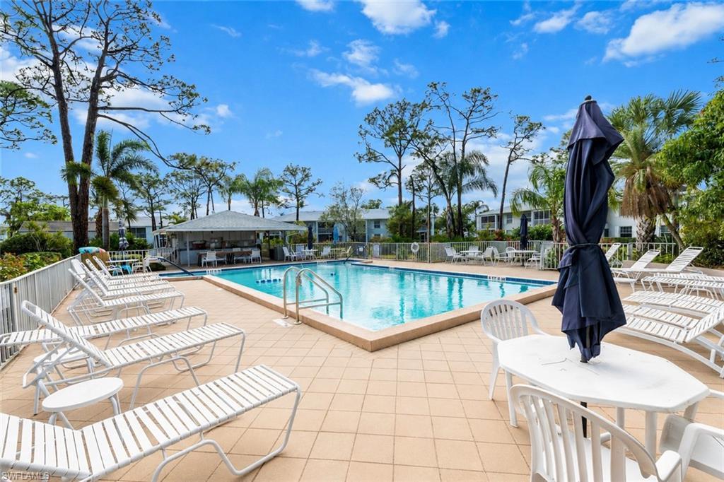 Image 2: Community swimming pool featuring a perimeter fence and an adjacent covered cabana