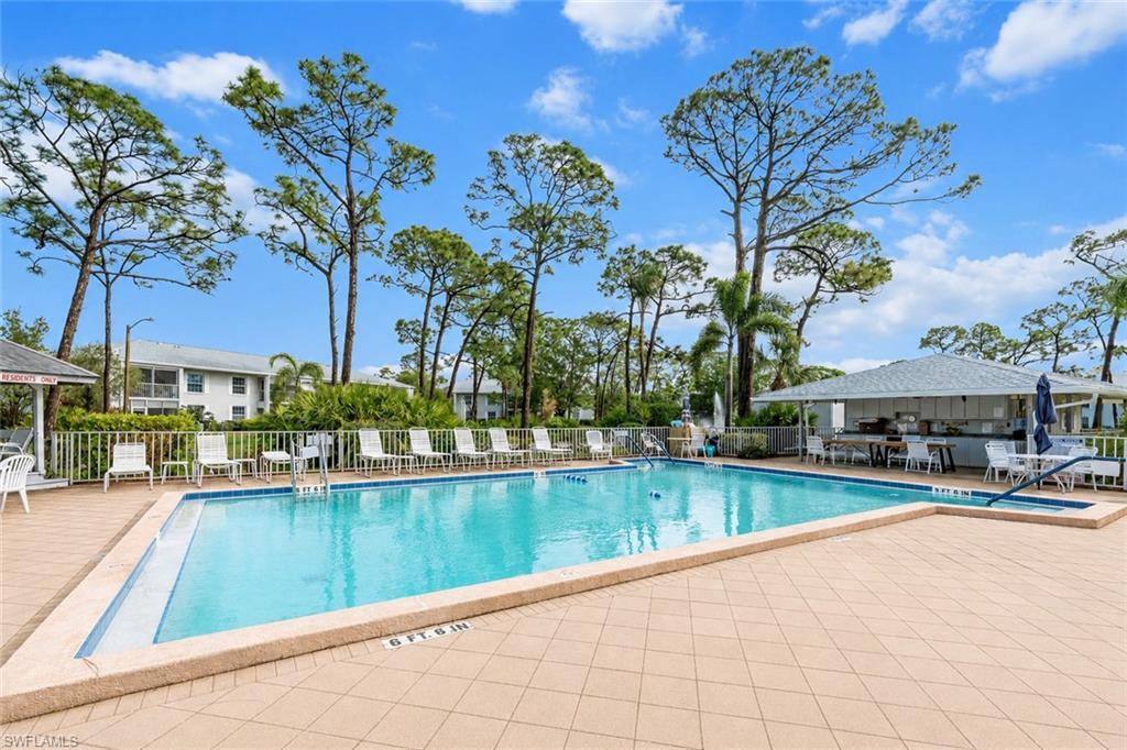 Image 3: Rectangular swimming pool with a surrounding tiled deck and multiple lounge chairs