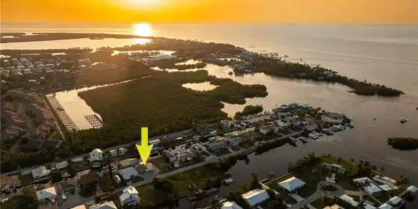 Image 2: Aerial view at dusk of a water view and a residential view