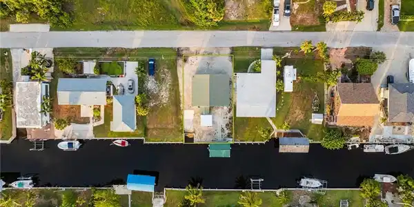 Image 3: Aerial perspective of suburban area featuring a nearby body of water