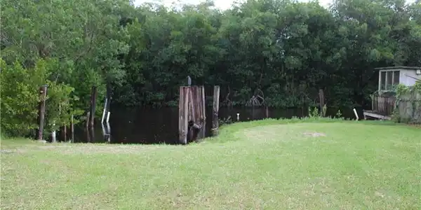 Image 4: View of green lawn featuring a boat slip.