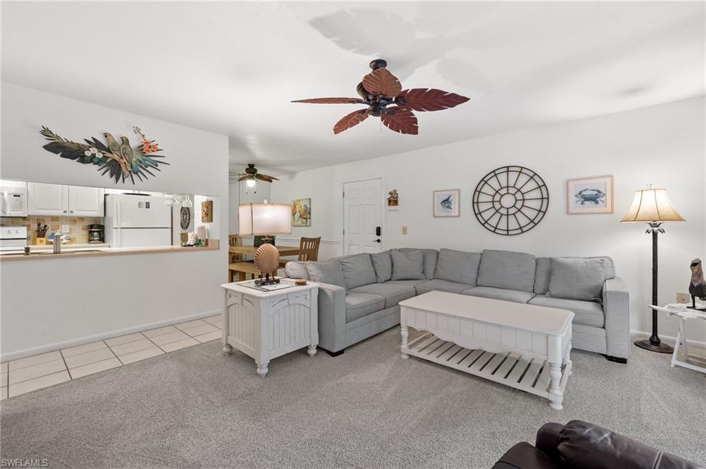 Image 4: Living room featuring ceiling fan, light colored carpet, and light tile patterned flooring