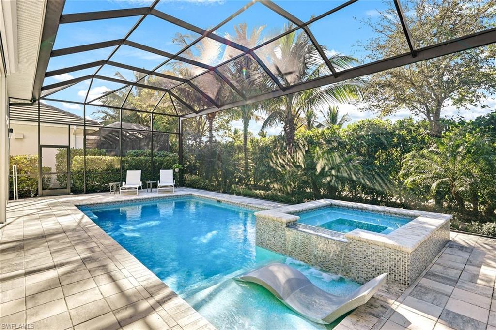 Image 3: Screened-in outdoor living space featuring a swimming pool, integrated spa with mosaic tile, and a built-in sun shelf