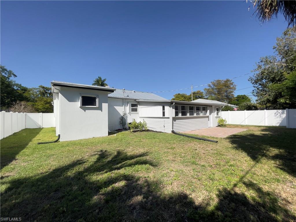 Image 4: Back of house with a fenced backyard