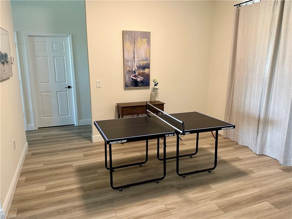 Image 3: Recreation room with light wood-style floors and baseboards