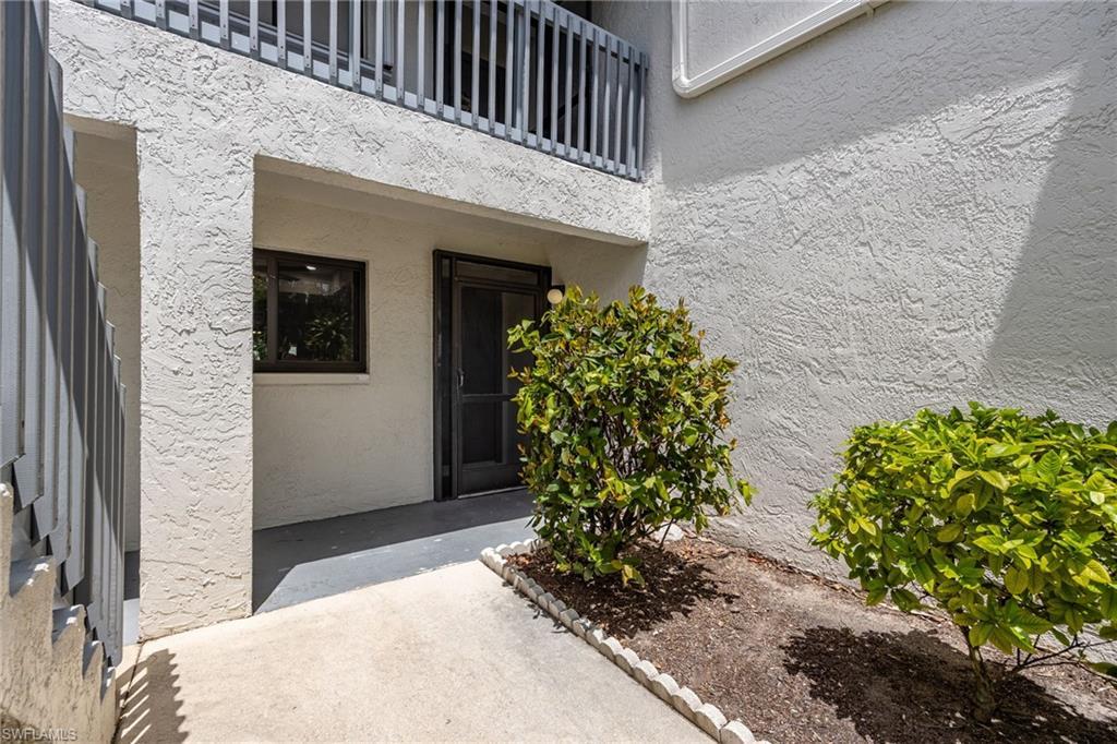 Image 4: View of exterior entry featuring stucco siding and a balcony