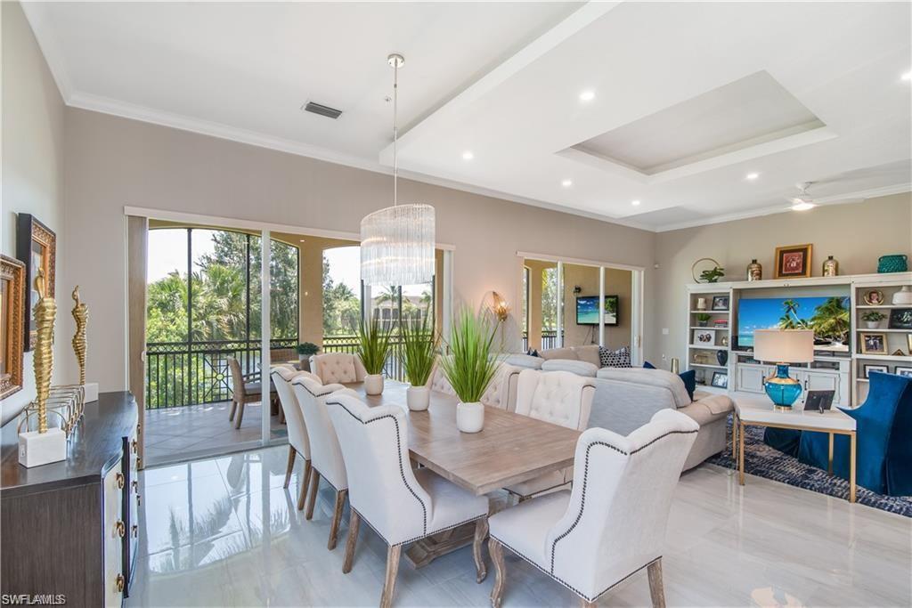 Image 3: Dining room with crown molding, a chandelier, healthy amount of natural light, recessed lighting, and a raised ceiling
