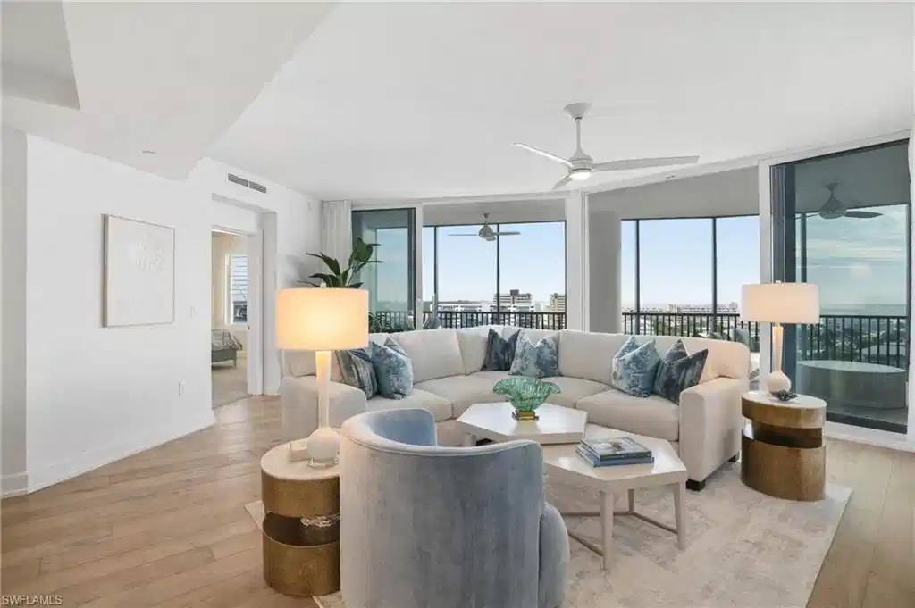 Image 1: Living area featuring expansive windows, healthy amount of natural light, and light wood finished floors - Virtually Edited Image