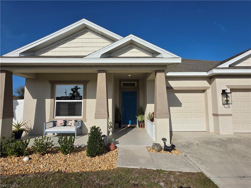 Image 3: View of front of house featuring stucco siding, an attached garage, a porch, and driveway