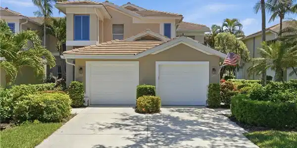 Image 3: Two-story residence featuring a tile roof, stucco exterior, and a two-car garage
