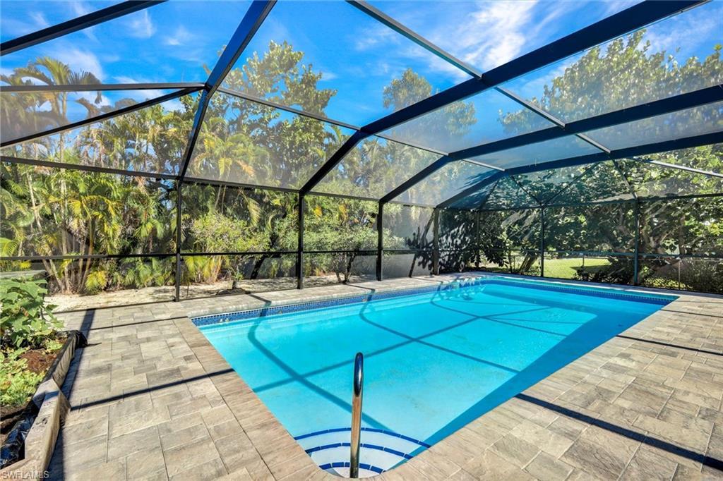 Image 1: Outdoor pool featuring a lanai and a sunroom