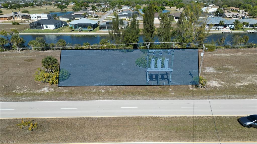 Image 2: Aerial view of residential area with a nearby body of water