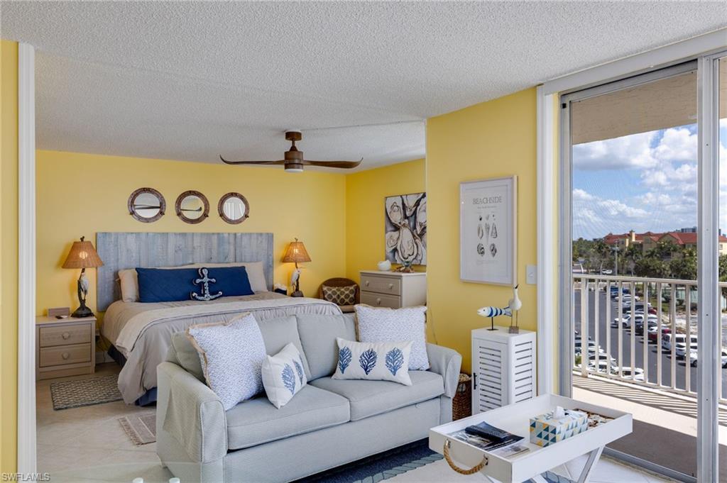 Image 2: Tiled bedroom featuring access to exterior, a textured ceiling, a ceiling fan, and floor to ceiling windows