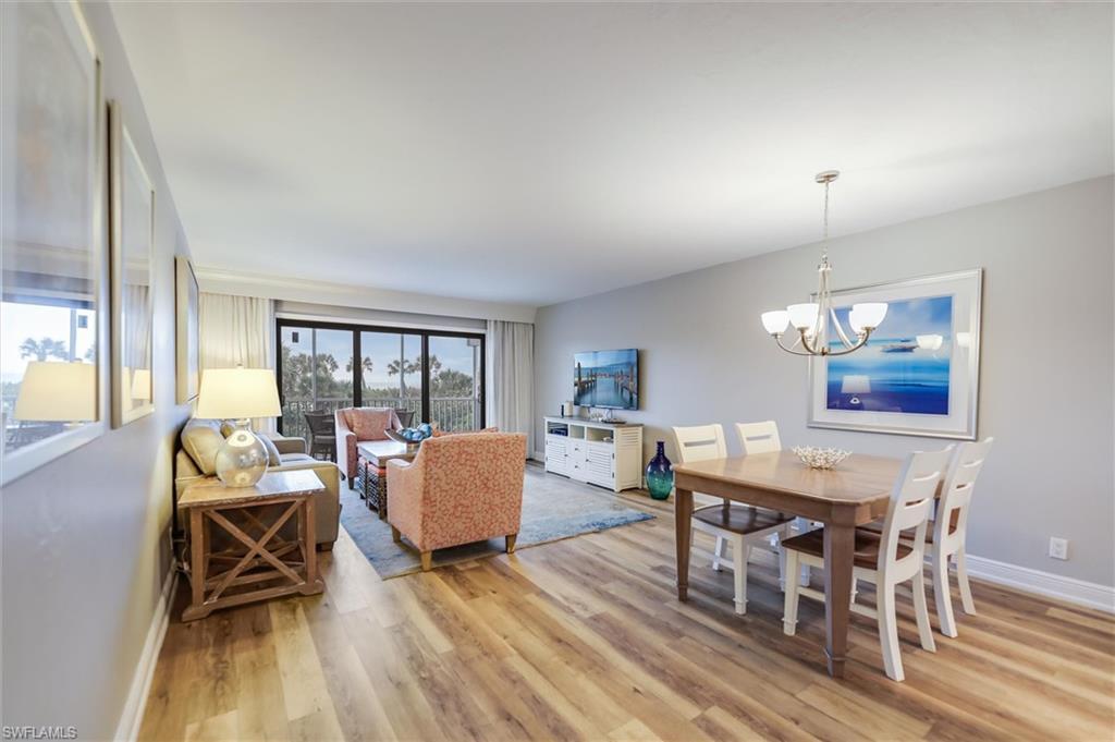 Image 4: Dining room with an inviting chandelier and light hardwood / wood-style floors
