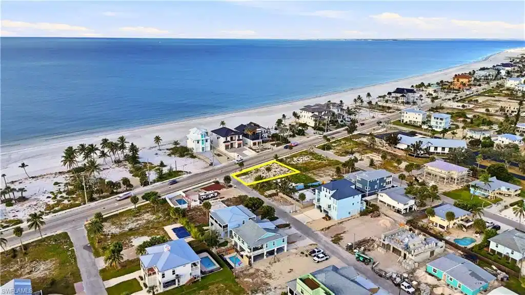 Image 1: Aerial view of residential area featuring expansive beach
