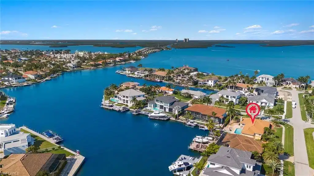 Image 1: Aerial view of property's location featuring a nearby body of water and nearby suburban area