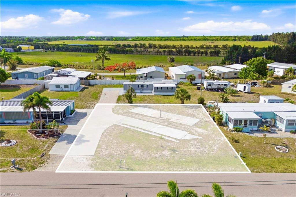 Image 1: Cleared lot featuring a paved driveway and visible utility hookups