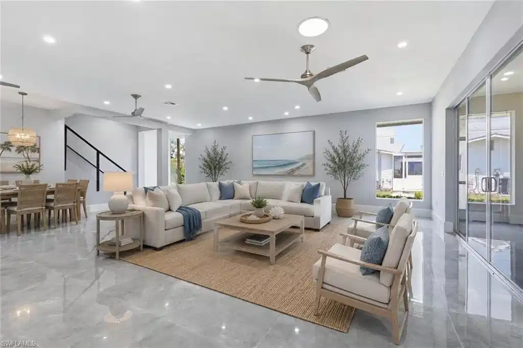 Image 1: Expansive open-concept living area featuring contemporary ceiling fans, recessed lighting, and large format polished tile flooring