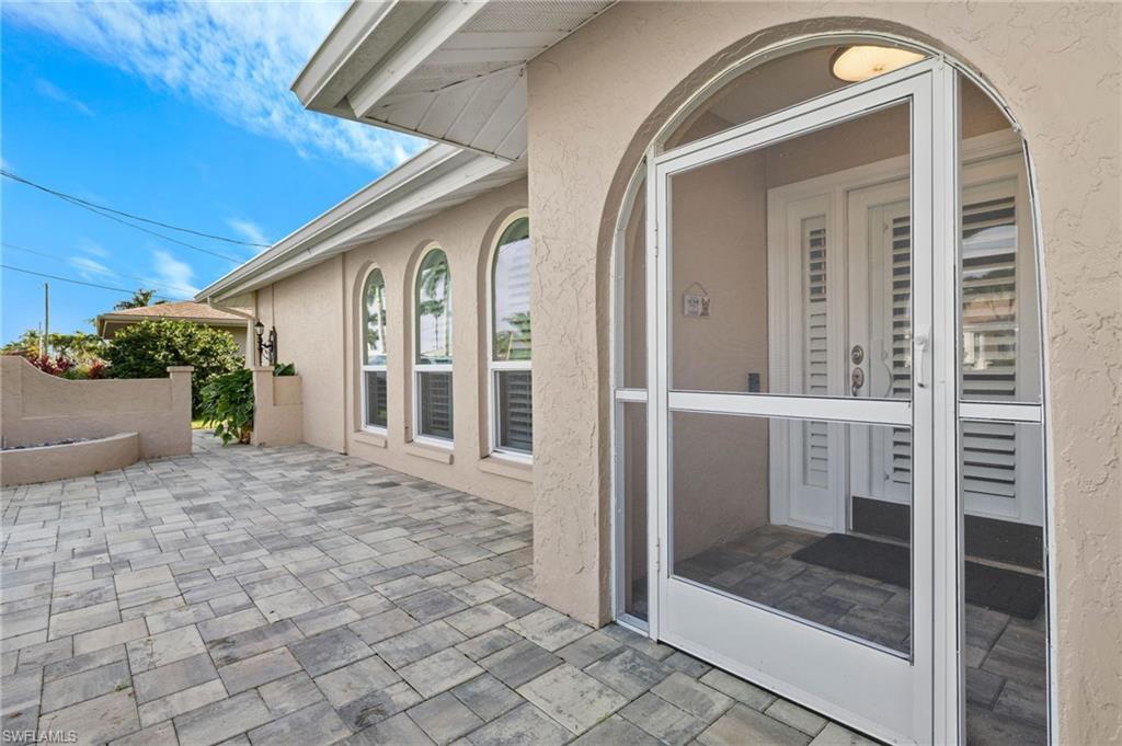 Image 4: Property entrance featuring stucco siding and a patio