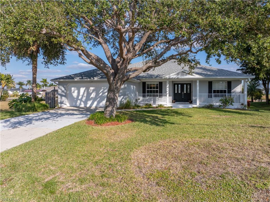 Image 1: Ranch-style home with concrete driveway, a front yard, covered porch, and roof with shingles