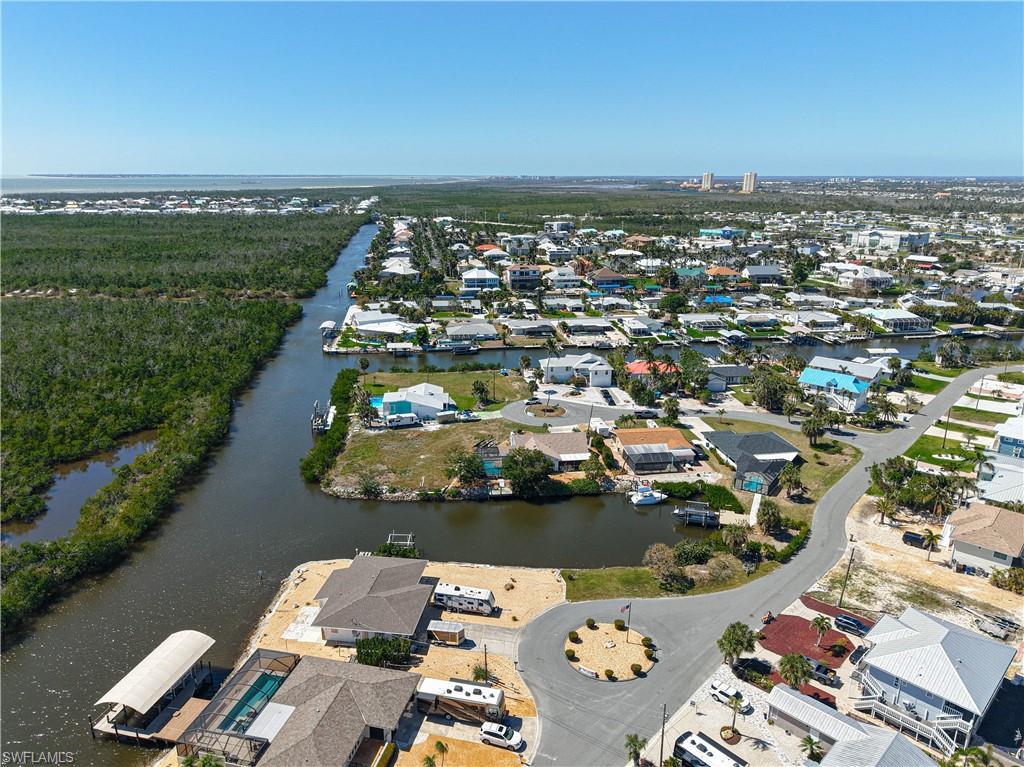 Image 4: Aerial overview of property's location featuring a nearby body of water and nearby suburban area