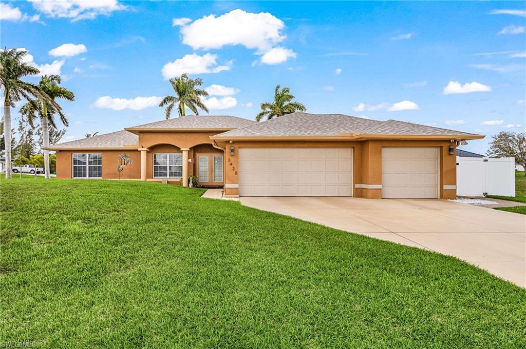 Image 2: View of front facade with a front yard, stucco siding, and a garage