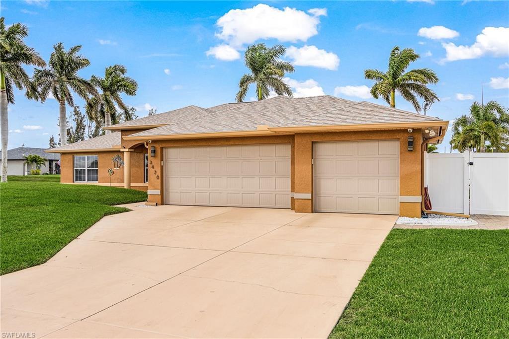 Image 3: Ranch-style house featuring roof with shingles, an attached garage, a front yard, a gate, and driveway