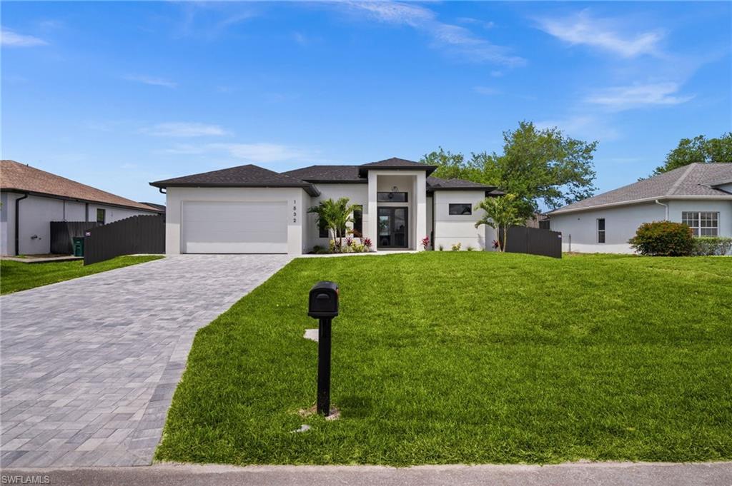 Image 2: Contemporary single-story residence featuring a dark shingle roof, white exterior, and a two-car garage