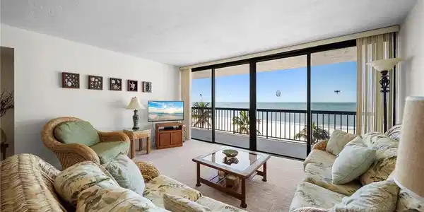 Image 4: Carpeted living room with expansive windows and a textured ceiling