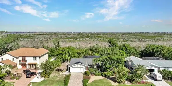 Image 3: Aerial view of property and surrounding area featuring a heavily wooded area