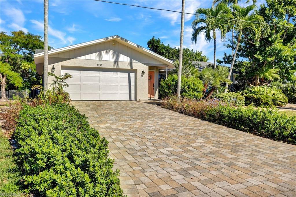 Image 4: View of front of house with decorative driveway and an attached garage