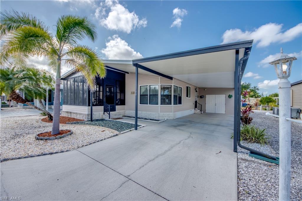 Image 1: View of front of home featuring a sunroom, a carport, concrete driveway, and a patio