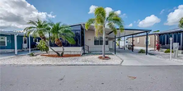 Image 2: Manufactured / mobile home with concrete driveway and a carport