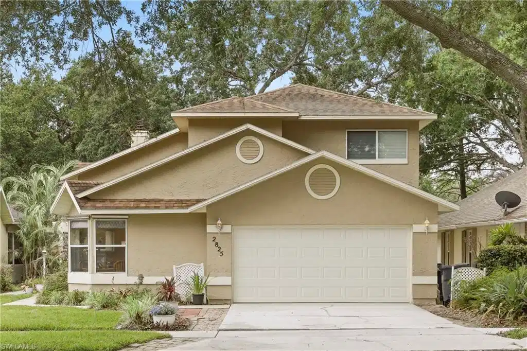 Image 1: Two-story stucco exterior with a prominent two-car garage