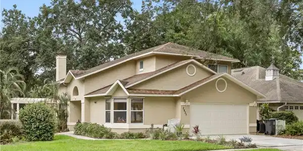 Image 2: Stucco-clad residence featuring multiple gables and a two-car garage