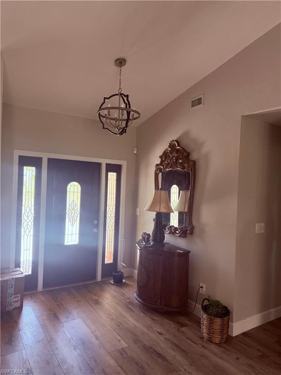 Image 4: Foyer entrance with a chandelier and wood finished floors