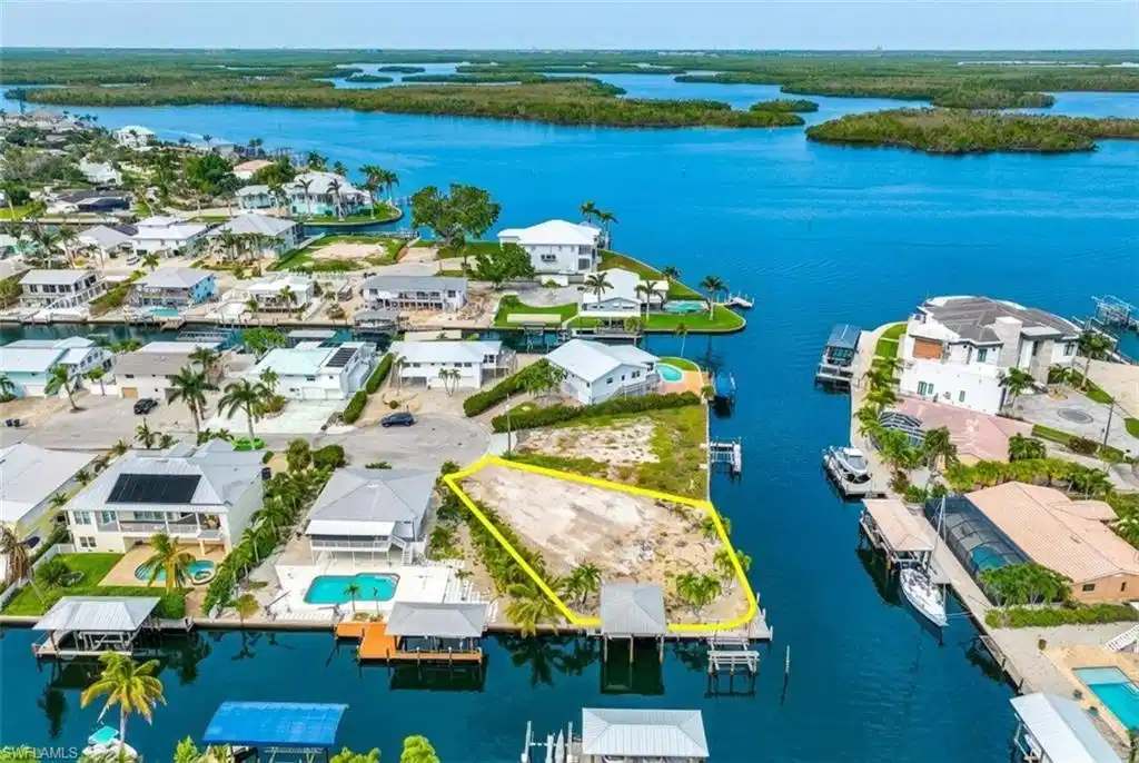 Image 1: Waterfront lot with direct Gulf access, featuring a private boat dock and canal frontage - Virtually Edited Image