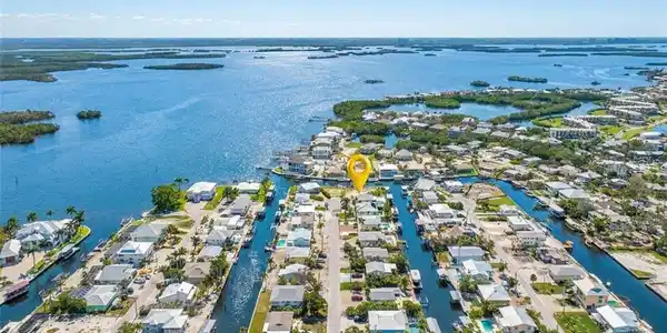 Image 3: Aerial perspective showcasing a canal-front property within a waterfront community - Virtually Edited Image