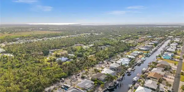 Image 2: Aerial view of property and surrounding area featuring nearby suburban area and a nearby body of water