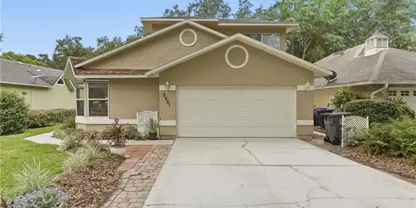 Image 3: Stucco exterior featuring a two-car garage, bay window, and a brick paver walkway