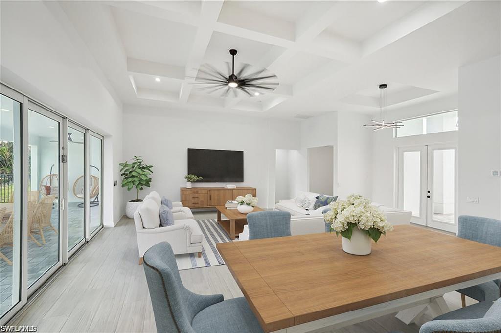 Image 3: Dining space with a towering ceiling, a chandelier, french doors, beamed ceiling, and coffered ceiling