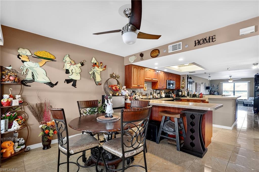 Image 1: Dining area with ceiling fan, recessed lighting, light tile patterned flooring, and a tray ceiling