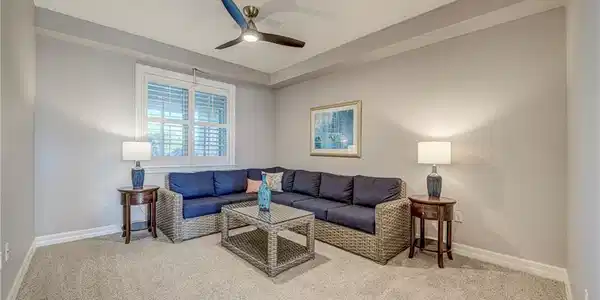 Image 3: Carpeted room featuring a ceiling fan with integrated lighting, a window with plantation shutters, light gray walls, and white baseboards