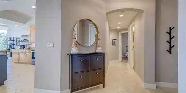 Image 4: Hallway with tile flooring and recessed lighting, featuring an arched entryway and light neutral wall paint