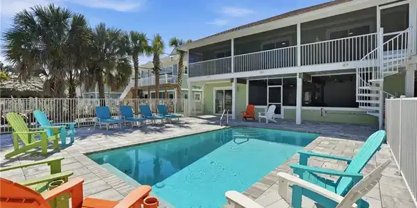 Image 2: View of swimming pool with patio surround, a balcony, and a sunroom - Virtually Edited Image