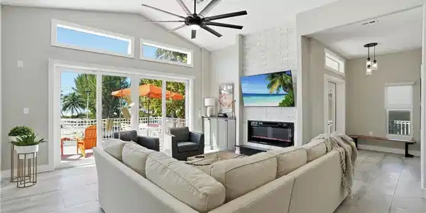 Image 3: Living area with a ceiling fan, a large fireplace, vaulted ceiling, and recessed lighting - Virtually Edited Image