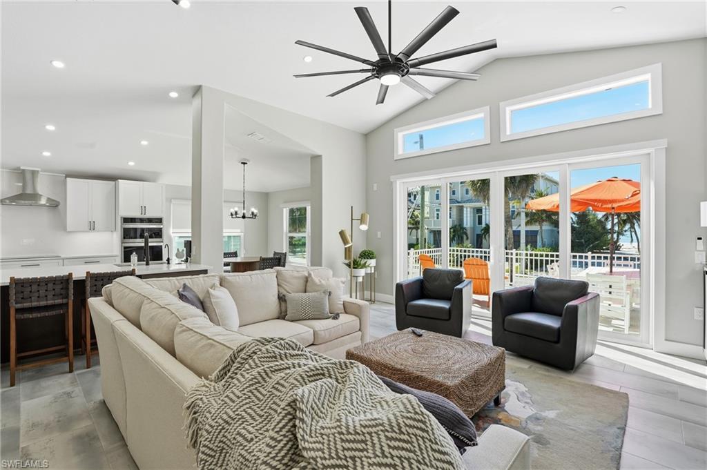 Image 4: Living area featuring a ceiling fan, suspended lighting, and vaulted ceiling - Virtually Edited Image