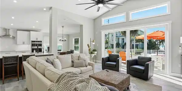 Image 4: Living area featuring a ceiling fan, suspended lighting, and vaulted ceiling - Virtually Edited Image