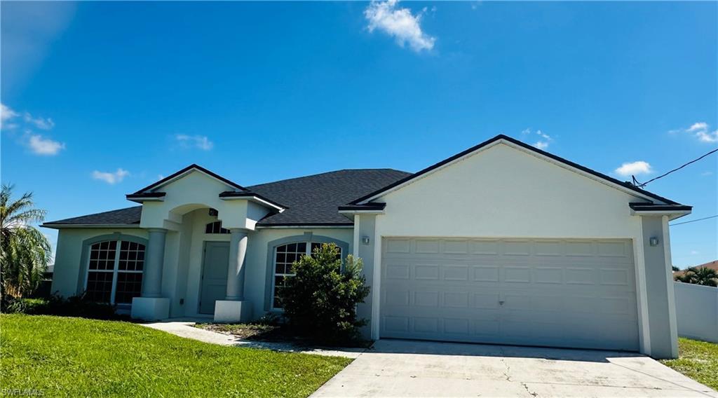Image 1: Ranch-style home featuring a shingled roof, stucco siding, concrete driveway, and a garage